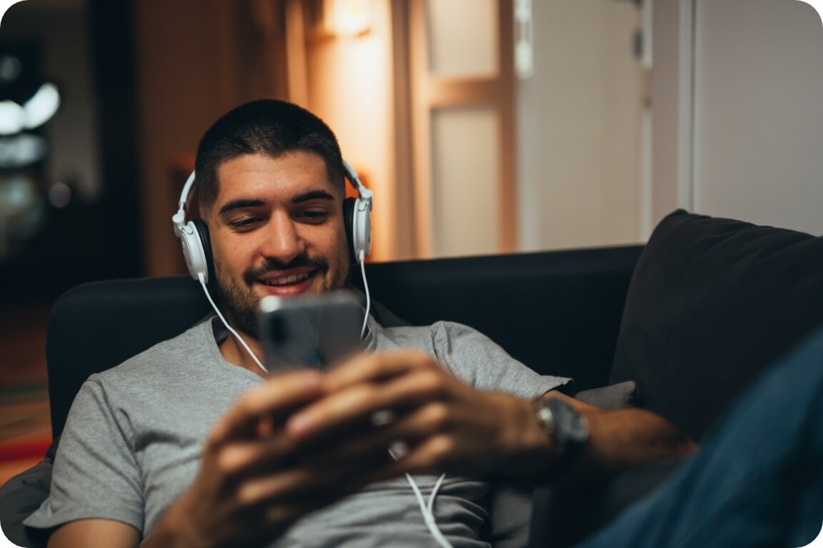 A young man mixing some tunes on his couch.