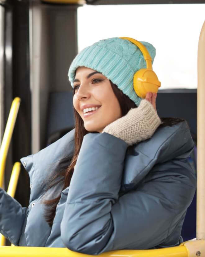 A young woman grooving to some music on her way to school.